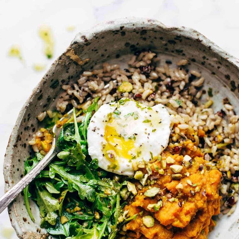 Bowl with rice, sweet potatoes, greens, and a poached egg.