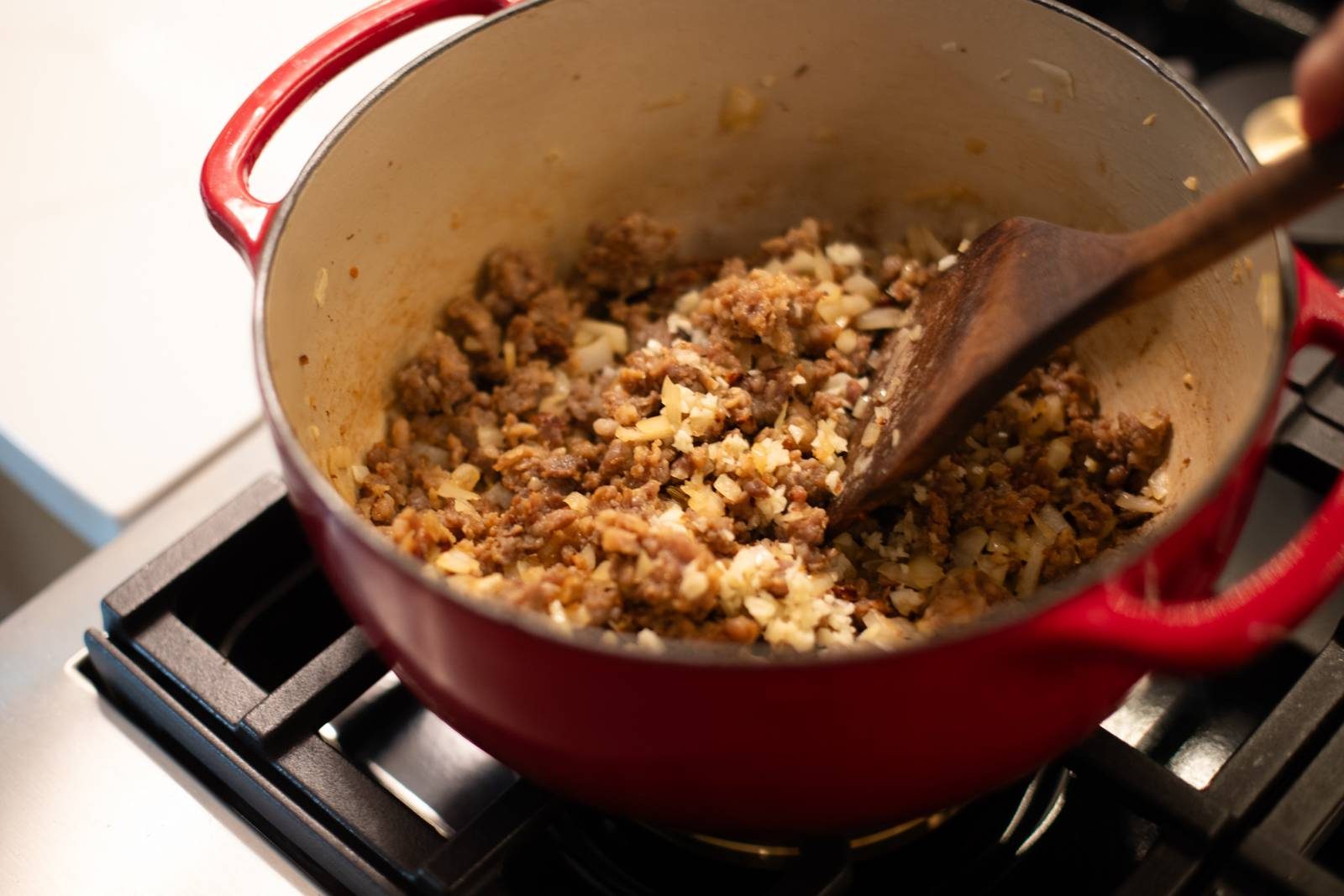Browning sausage and onion in a dutch oven.