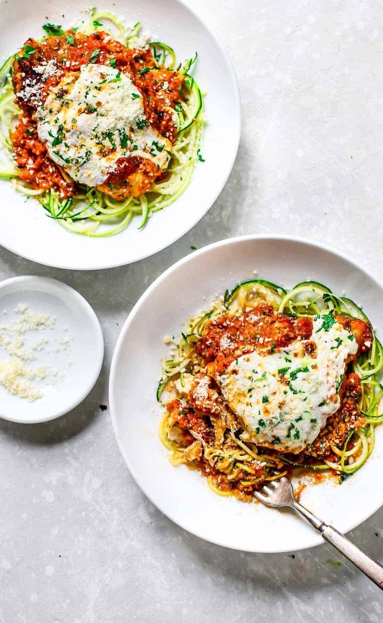 Chicken parmesan on a plate of zucchini noodles.